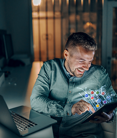 handsome-caucasian-bearded-freelancer-with-toothy-smile-sitting-in-office-late-at-night-and-using-tablet-for-surfing-the-internet-social-media-concep2t